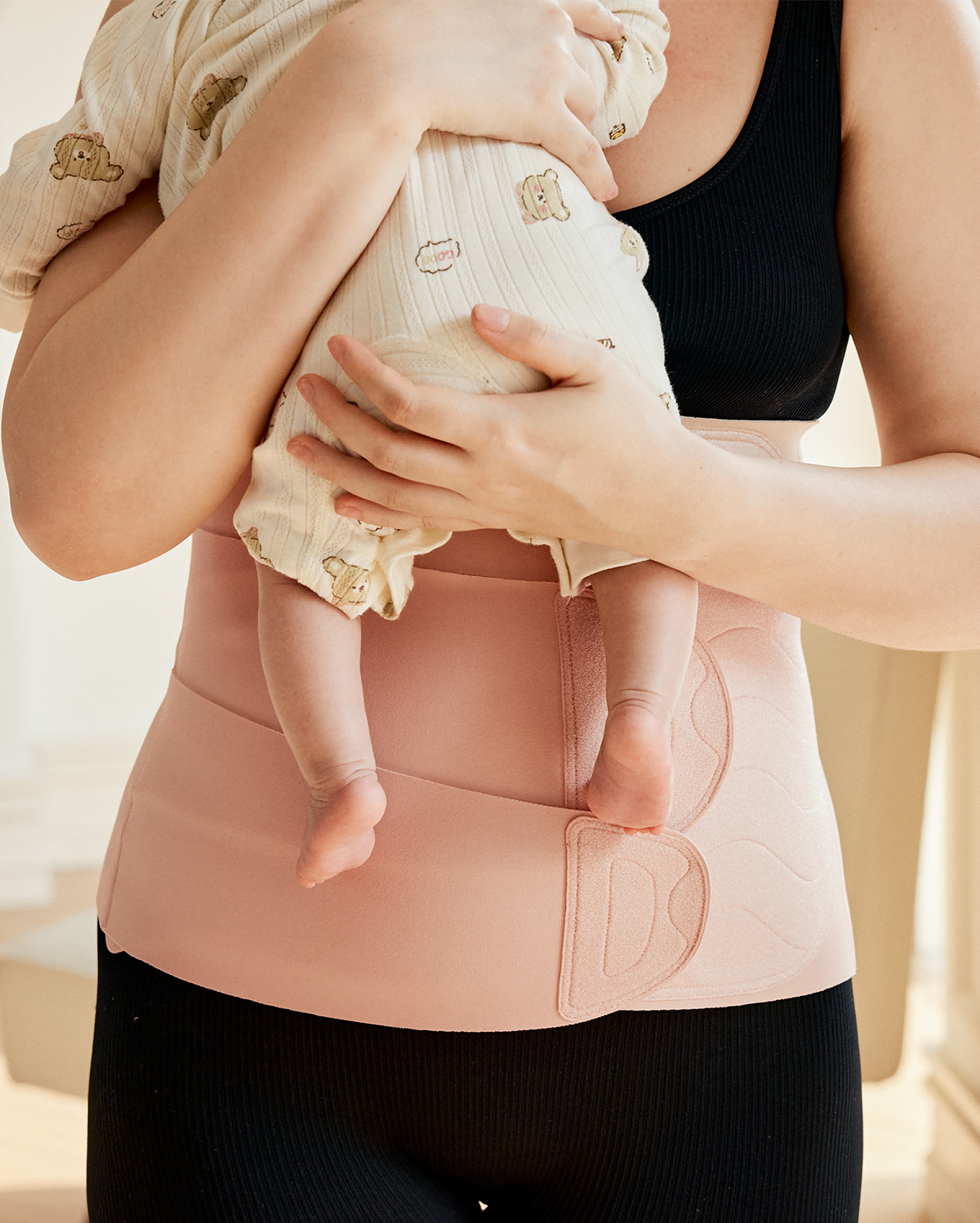 Momcozy Ergowrap Postpartum Belly Band in oyster pink color, supporting new mom and baby
