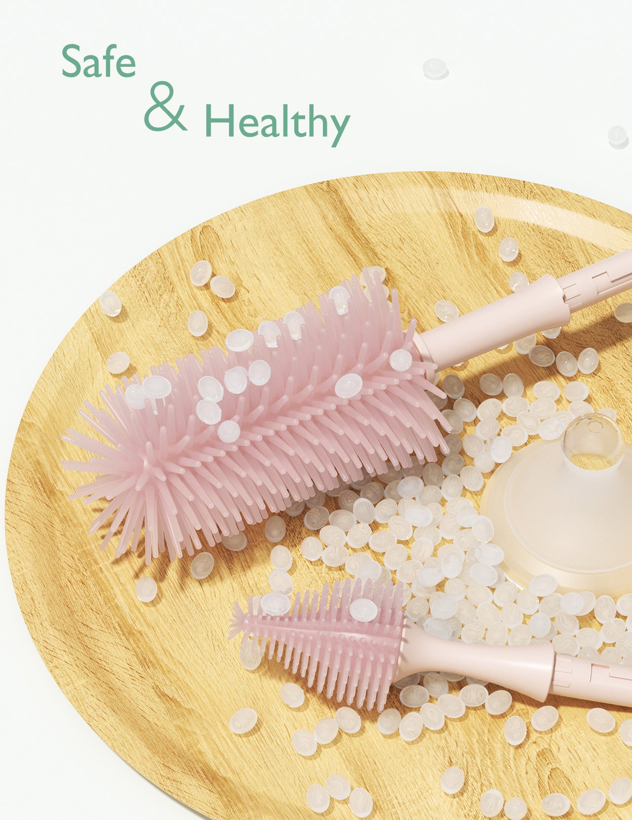 Momcozy pink bottle brushes and cleaning pellets on a wooden tray, promoting safe cleaning.