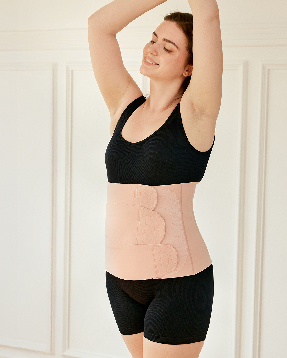 Momcozy Ergowrap Postpartum Belly Band in oyster pink color worn by a woman, featuring adjustable straps for postpartum support.