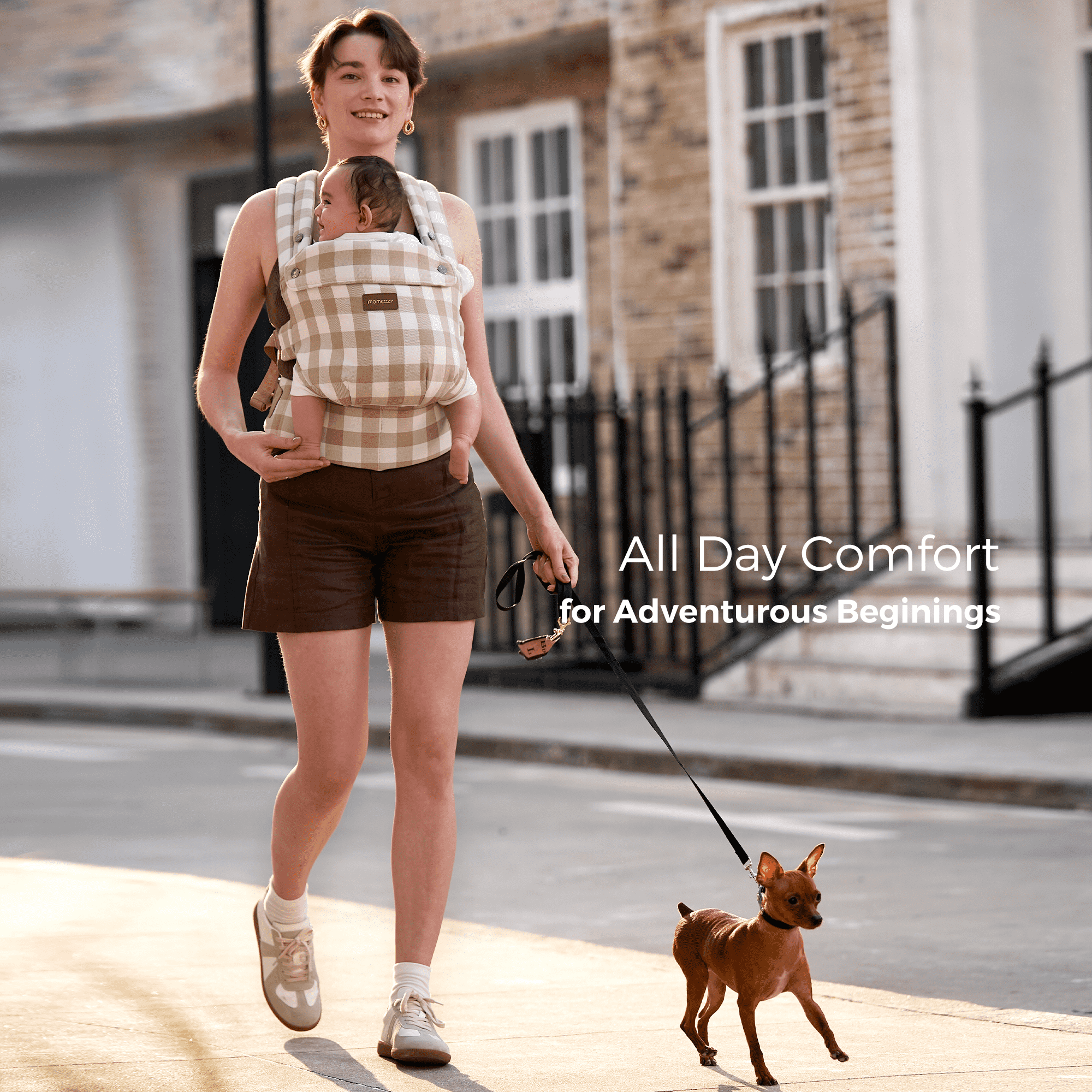 Momcozy PureHug baby carrier in beige gingham, all-day comfort for babywearing while walking a dog