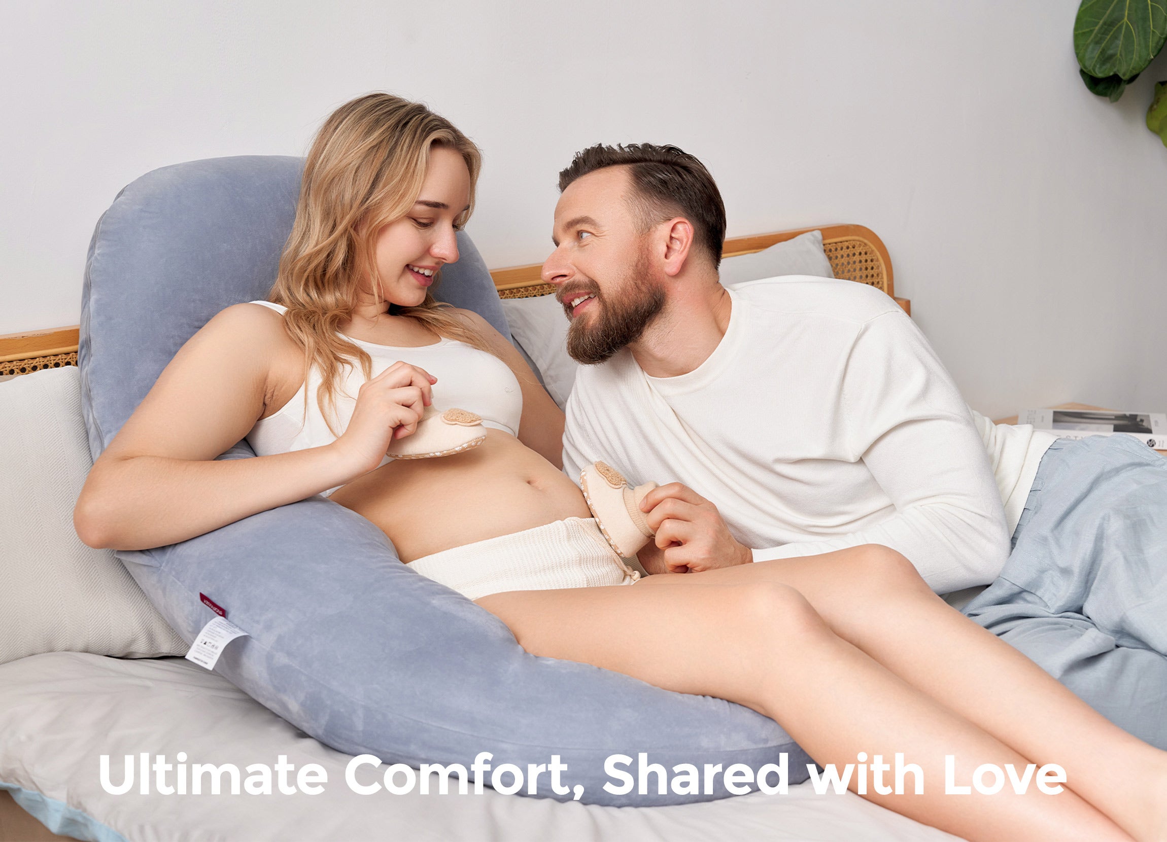 Pregnant woman with partner using Momcozy Dreamlign pillow. Ultimate Comfort, Shared with Love.