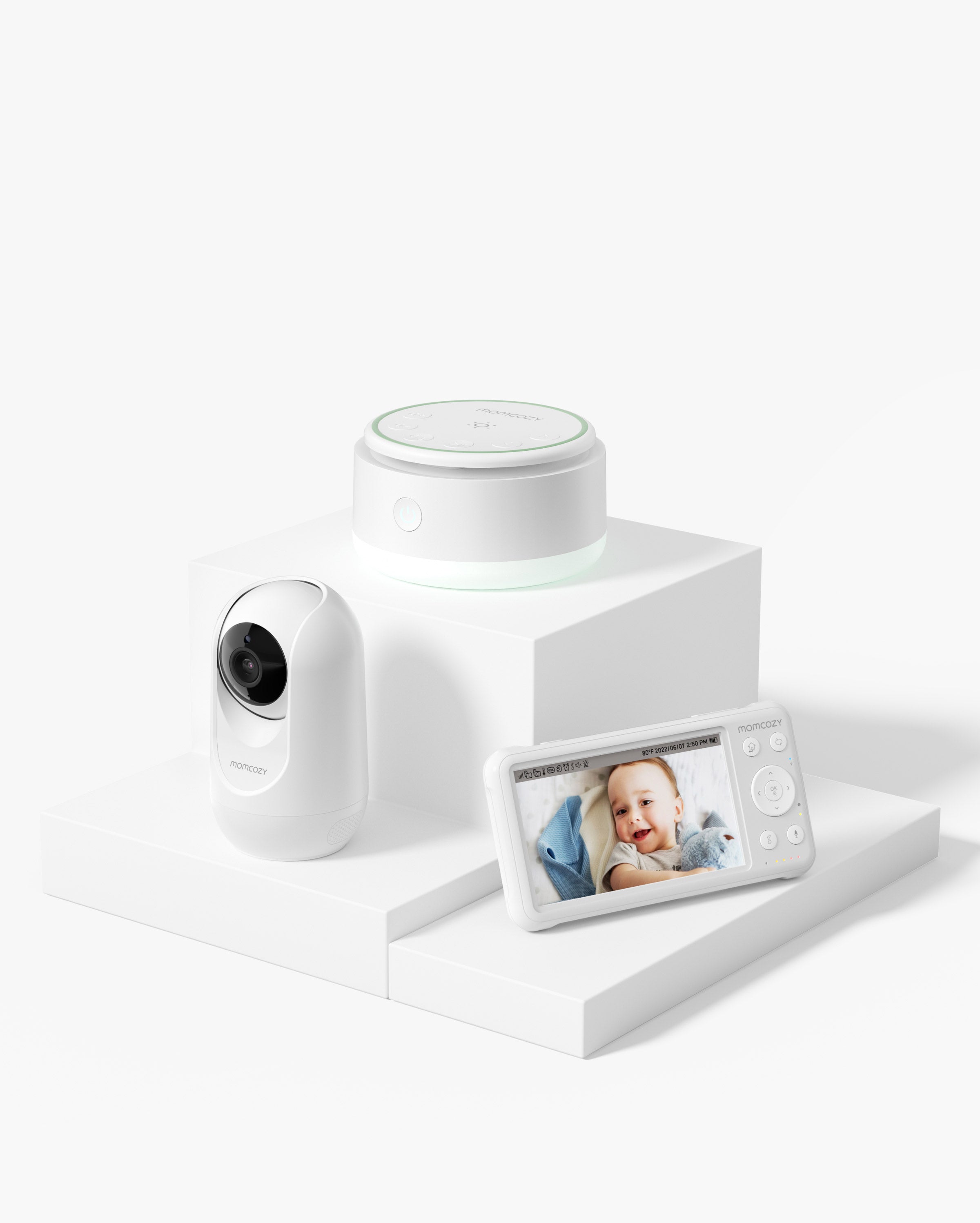 Baby care bundle including portable baby sound machine, baby monitor camera, and baby monitor screen showing a sleeping baby.