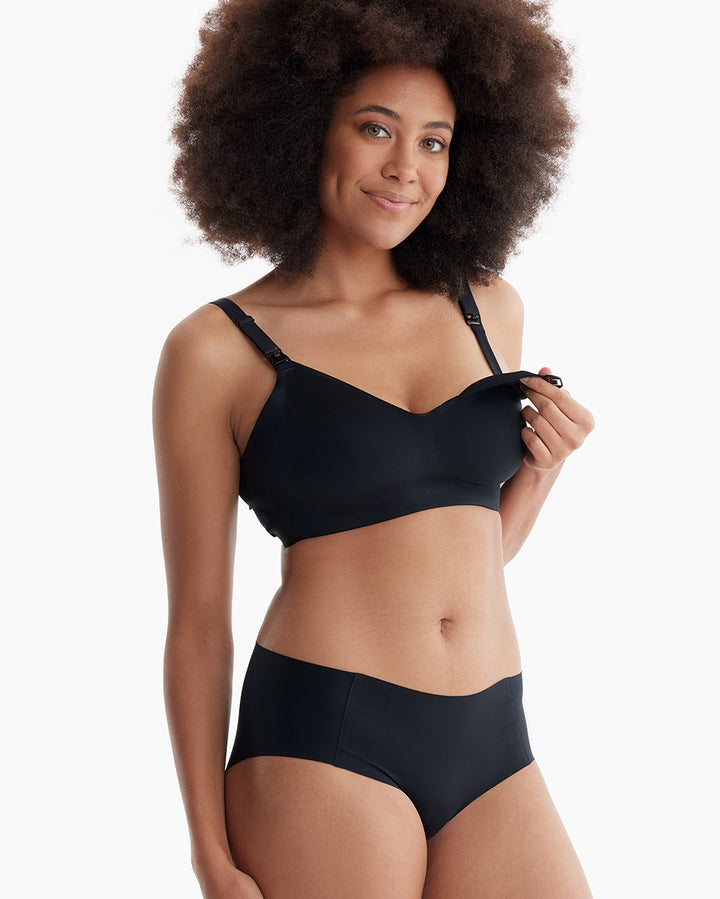 Model showcasing black pumping bra with revealing front for breastfeeding convenience.